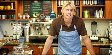 Picture of a business owner at the counter in his shop.